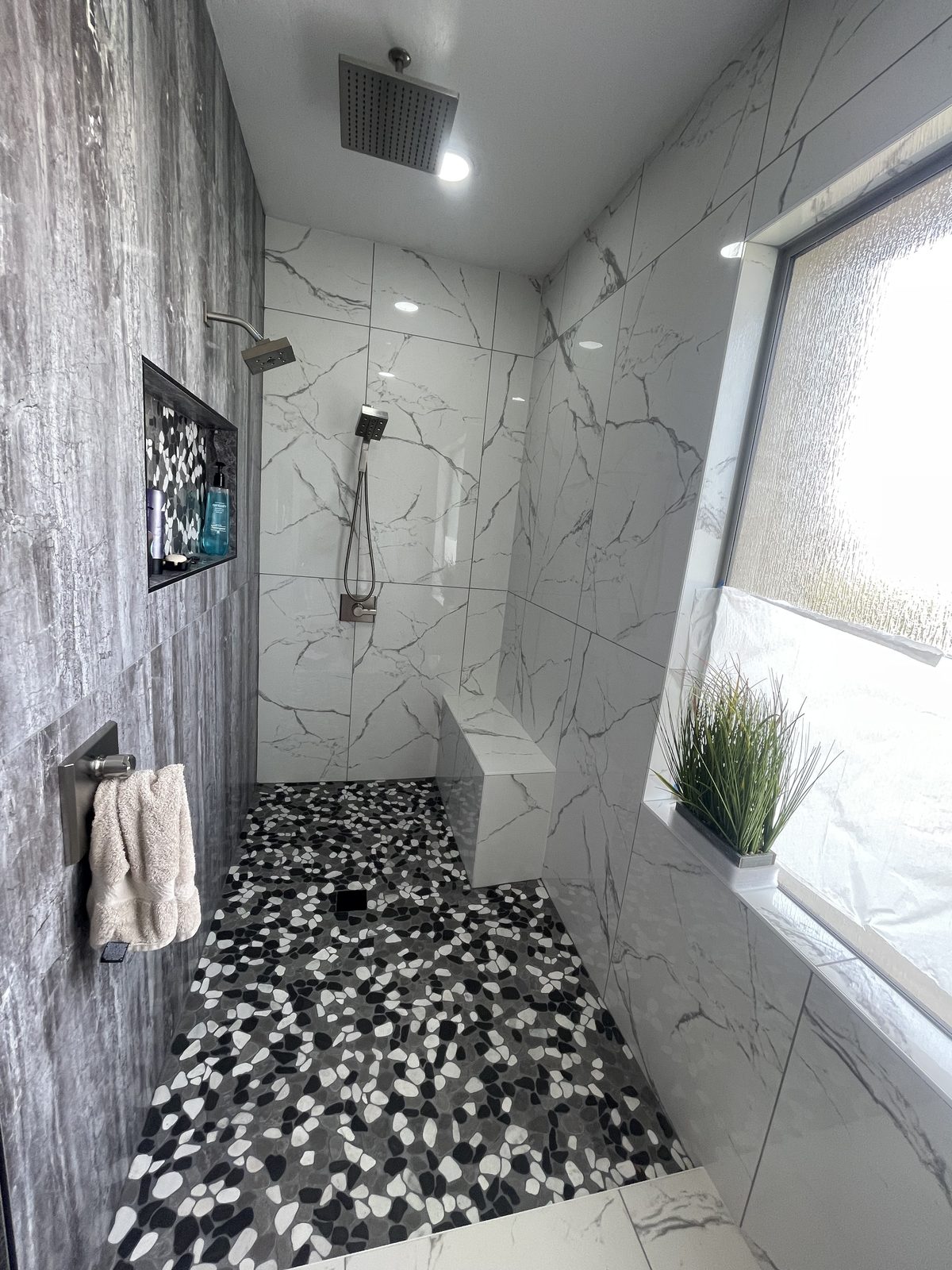 Tiled walk-in shower with pebble floor